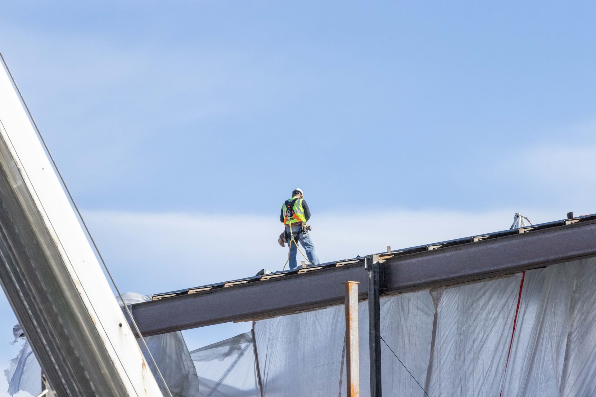 Technicien installant un pare-feuilles sur une gouttière